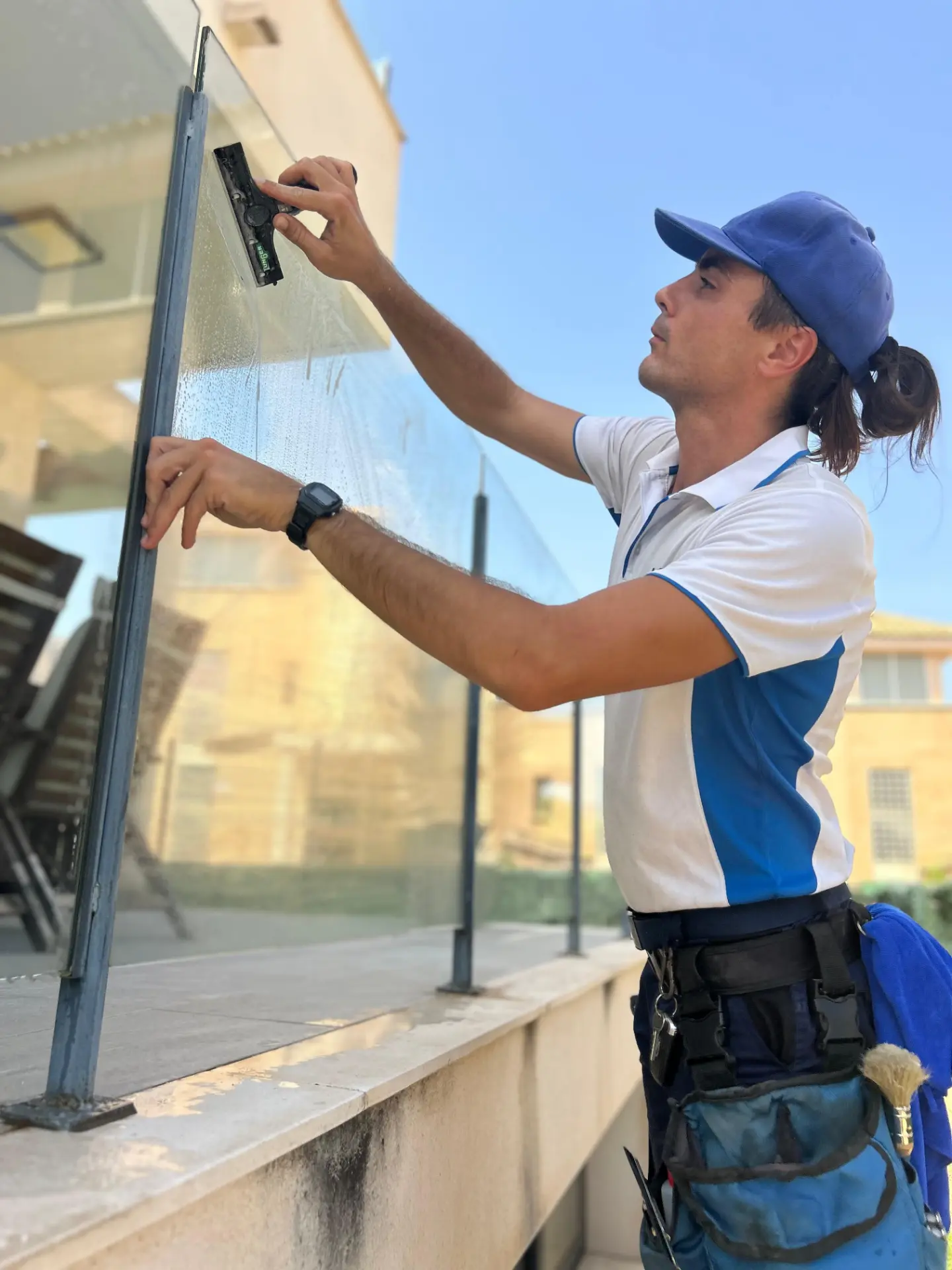 Técnico de MIRESA limpiando una barandilla de cristal con mojador profesional
